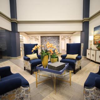 A modern lobby with elegant blue chairs and a central table adorned with decorative elements.