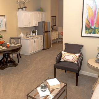 A cozy apartment interior featuring a small kitchenette and living area.