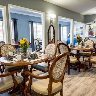 An elegant dining room with beautifully set tables and classic chairs.