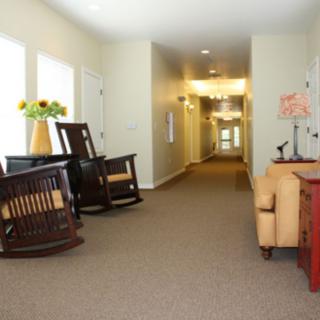 A cozy hallway featuring rocking chairs and a sofa with decorative elements.