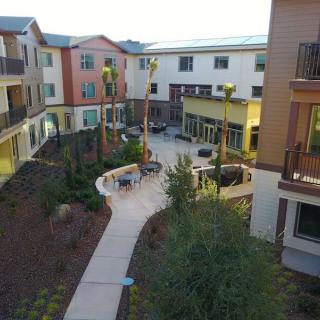 A view of a well-landscaped apartment complex courtyard with pathways and outdoor seating areas.