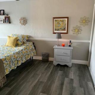 A cozy bedroom with a floral-themed bedspread and matching decor.