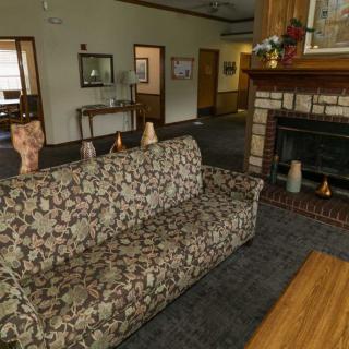 A cozy living room featuring a floral sofa and a fireplace.