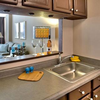A cozy kitchen with a sink, cutting board, and decorative items on the countertop.