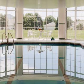 A serene indoor pool with large windows that offer a view of the outdoors, creating a tranquil atmosphere.