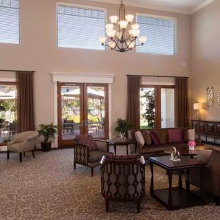 Elegant living room with large windows and a chandelier.