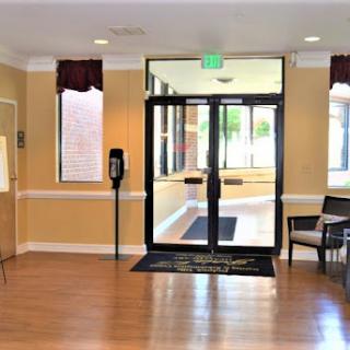 A welcoming lobby area featuring an entrance door, comfortable seating, and natural light.