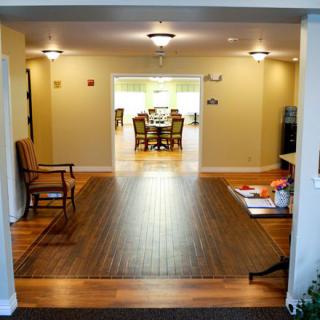 A spacious living area with hardwood floors leading to a dining room.