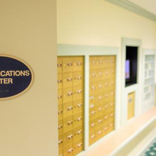 A mailroom area with wooden lockers and a communication center sign.