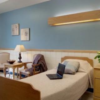 A cozy hospital room with a single bed and comfortable furnishings.