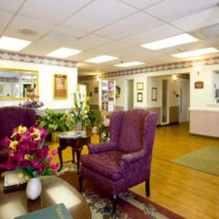 A cozy waiting room with comfortable chairs and floral decorations.