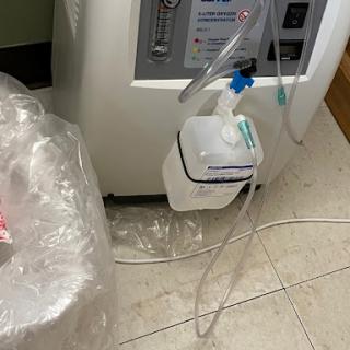 A close-up view of medical equipment with tubing and a disinfectant container in a hospital setting.