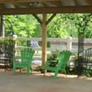A cozy outdoor seating area with green chairs under a pergola.