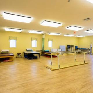 A spacious rehabilitation room equipped for physical therapy.