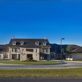 A large suburban house with a modern architectural design under a clear blue sky.