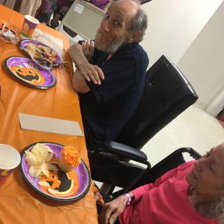 Two individuals seated at a table with festive plates of food, enjoying a meal together.