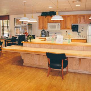 A modern kitchen interior with wooden cabinets and a spacious dining area.
