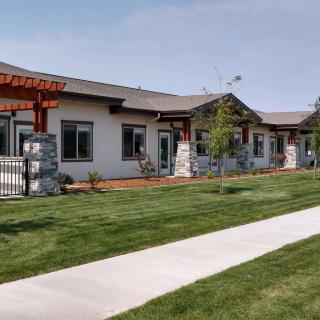 A modern residential building with well-maintained landscaping and a sidewalk.