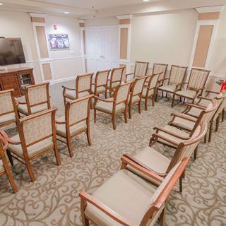 An empty conference room with rows of chairs arranged in a semi-circular pattern.