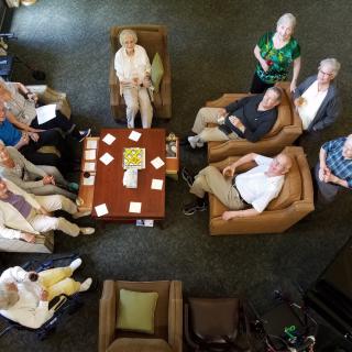 A group of seniors gathered in a seating area, viewed from above.