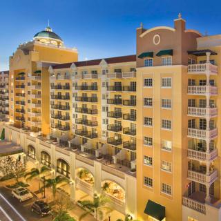 A luxurious hotel building illuminated at dusk with multiple balconies and architectural details.