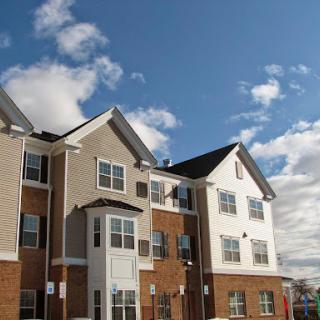 A modern residential apartment building under a clear blue sky.