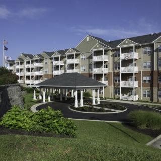 A multi-story residential apartment building with manicured landscaping.