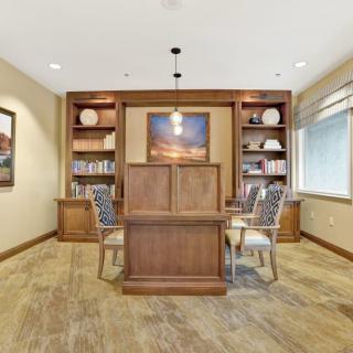 A neatly organized office space with wooden furniture and ample natural lighting.