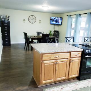 Open kitchen and dining area featuring a wooden island with a marble countertop.