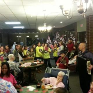 A group of people enjoying a musical performance in a festive indoor setting.