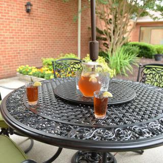 A refreshing pitcher of iced tea with glasses on a patio table.