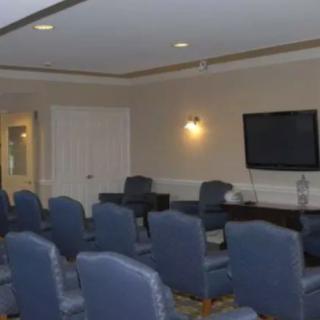 A small conference room with rows of chairs facing a television.