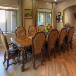 Elegant dining room with a long wooden table and upholstered chairs.