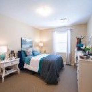 A cozy bedroom with a neatly made bed and elegant decor.