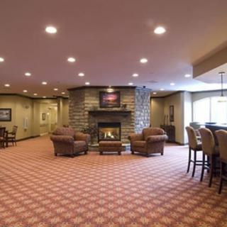 A spacious living room with a fireplace, comfortable seating area, and a bar counter.