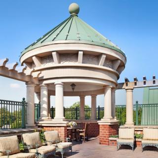 A scenic rooftop terrace featuring a classic gazebo with outdoor seating and decorative pergolas.