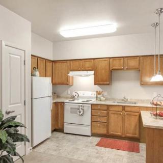 A cozy kitchen with wooden cabinets, a white refrigerator, and an oven.