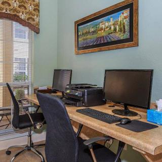 A well-organized office space with multiple workstations, computers, and a printer.
