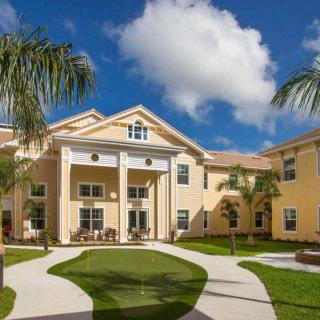 A sunny day at a residential building with palm trees and blue skies.