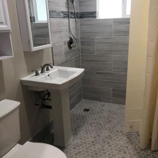 Modern bathroom with a pedestal sink and walk-in shower.
