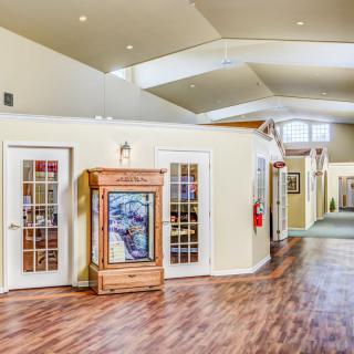 A spacious hallway with wooden flooring and multiple doors leading to adjacent rooms.