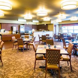 A spacious dining area with modern lighting and neatly arranged tables and chairs.