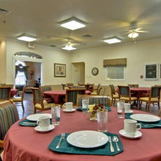 A neatly set dining room with multiple tables and chairs, ready for guests.