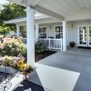 A charming front porch with blooming flowers on a sunny day.