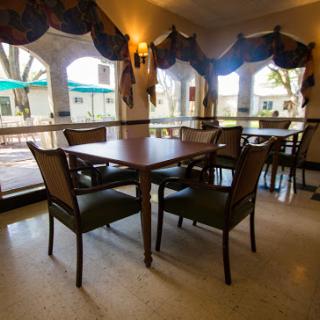 A cozy dining area featuring a wooden table and chairs with a view through the windows.