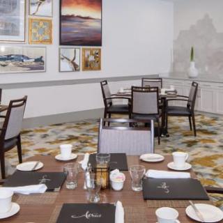 An elegant dining area with neatly arranged tables and wall artwork.
