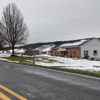 A quiet winter scene featuring a snowy landscape with houses lining a rural road.