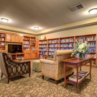 A cozy library with shelves filled with books and comfortable seating.