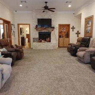A cozy living room featuring comfortable recliners, a fireplace, and a TV.