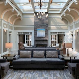A modern living room with a skylight, featuring a cozy sofa and a central fireplace.